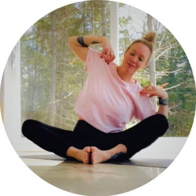 Femme en posture de yoga assise travaillant la mobilité des hanches et le renforcement du haut du corps dans un espace lumineux